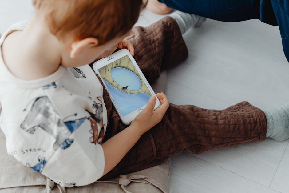 A young child playing an educational game on a smartphone indoors, focused on learning.