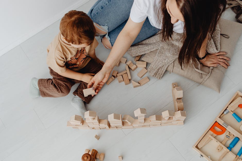 Mother and child spending quality time playing with wooden blocks on the floor.